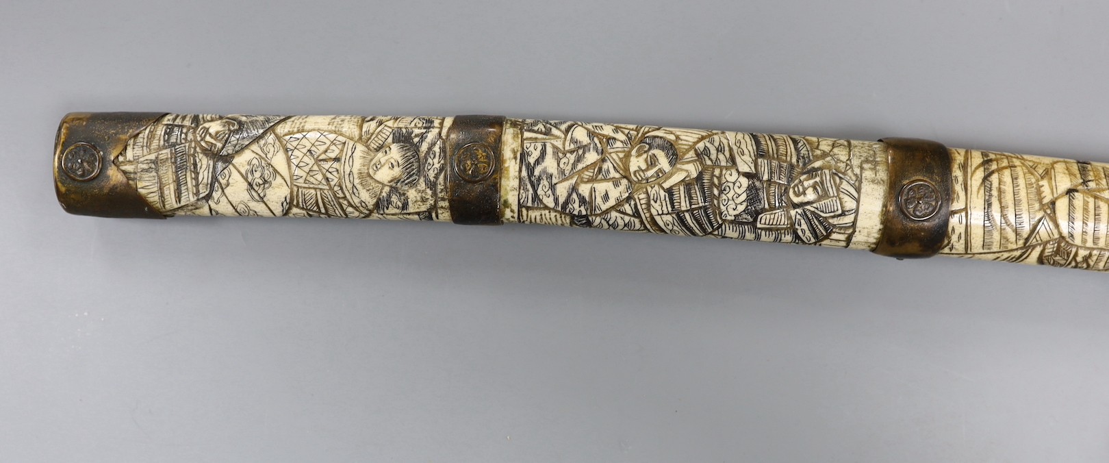 A late 19th century Japanese wakizashi sword, the blade 47.5cm, with sectional stag's horn scabbard and hilt carved with warriors and other figures, gilt metal mounted